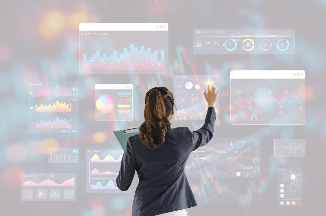 Back facing woman at large tech dashboard